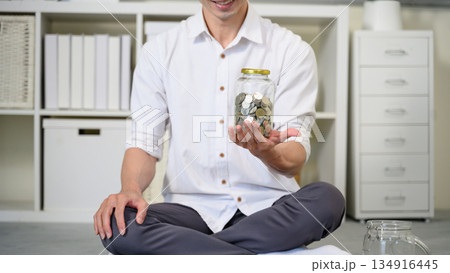 Closeup man holding jar of coin, Saving concept Closeup man holding jar of coin, Saving concept 134916445