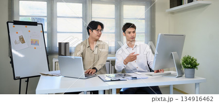 Two colleague analysis business data in computer at workplace Two colleague analysis business data in computer at workplace 134916462
