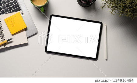 Digital tablet on office desk workspace with, pen, laptop, flower and hot coffee cup on white table 134916484