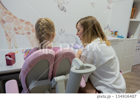 Mother tutoring daughter at desk pink chairs giraffe wall mural notebook pencil focused warm atmosphere evening routine study coach guiding handwriting mother smile daughter concentration cozy nursery Mother tutoring daughter at desk pink chairs giraffe wall mural notebook pencil focused warm atmosphere evening routine study coach guiding handwriting mother smile daughter concentration cozy nursery 134916487