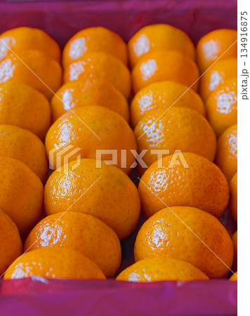 Fresh tangerines in boxes on the shelves of a grocery supermarket, tangerines on the shelves of a grocery store Fresh tangerines in boxes on the shelves of a grocery supermarket, tangerines on the shelves of a grocery store 134916875