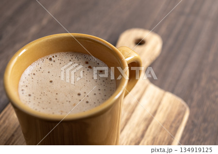 冬の午後のティータイムに楽しむ温かいカフェラテと木のぬくもり 134919125
