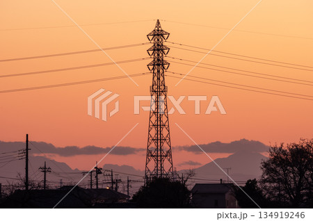 冬の夕焼けに染まる鮮やかなオレンジ色の空と送電線 134919246