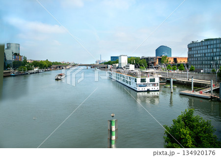 Large river cruise ship moored to left Seine riverbank (distant people on top desk) and small toarbot moving on Seine. Large river cruise ship moored to left Seine riverbank (distant people on top desk) and small toarbot moving on Seine. 134920176