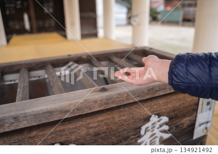 お賽銭箱にお金を投げる手 134921492