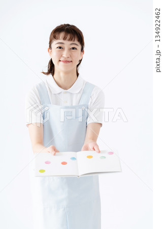 絵本を持つ保育士の女性 134922462