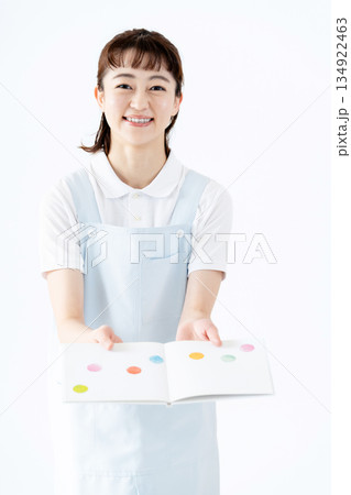 絵本を持つ保育士の女性 134922463