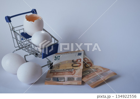 Commodity trading concept: eggs in a cart next to Euros, representing agricultural market Commodity trading concept: eggs in a cart next to Euros, representing agricultural market 134922556