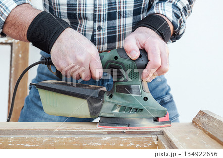 Carpenter at work, restoring an old wooden window. Carpentry. 134922656