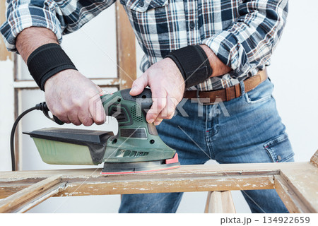 Carpenter at work, restoring an old wooden window. Carpentry. Carpenter at work, restoring an old wooden window. Carpentry. 134922659