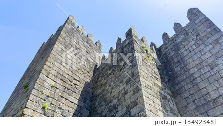 Close-up view of the medieval stone towers of Guimaraes Castle in Portugal, with crenellated 134923481