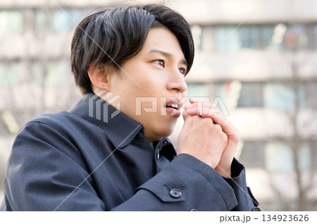 オフィス街で寒そうな男性 134923626