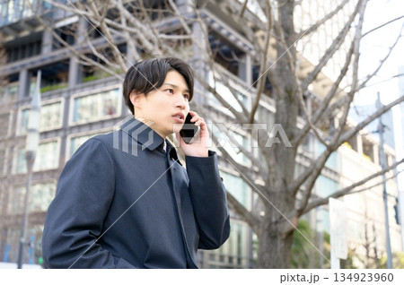 オフィス街でスマホを使用する男性 オフィス街でスマホを使用する男性 134923960