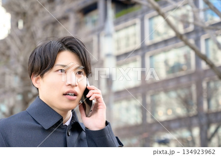 オフィス街でスマホを使用する男性 134923962