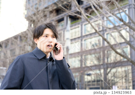 オフィス街でスマホを使用する男性 オフィス街でスマホを使用する男性 134923963