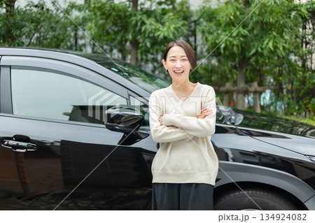 車の前に立つミドル女性 134924082