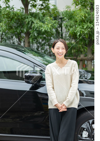 車の前に立つミドル女性 134924083