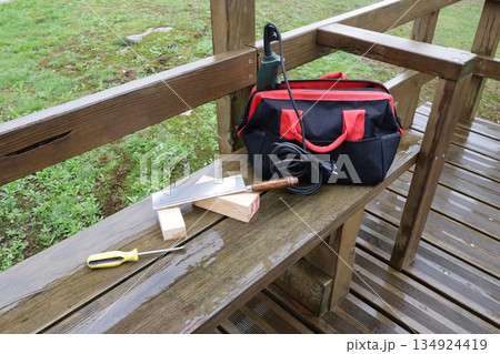 Carpenter tools and wooden blocks on a wet wooden bench outdoors Carpenter tools and wooden blocks on a wet wooden bench outdoors 134924419