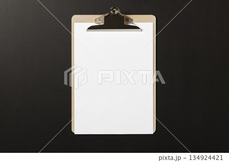 Blank white paper on wooden clipboard on dark background. template mock up 134924421