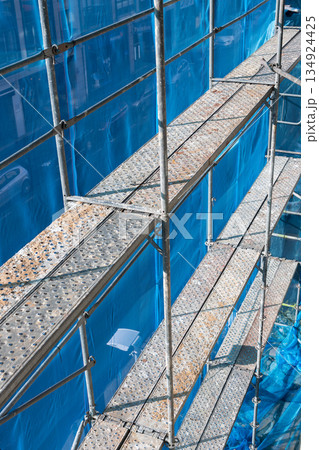 European style scaffolding structure with safety netting and platforms European style scaffolding structure with safety netting and platforms 134924425