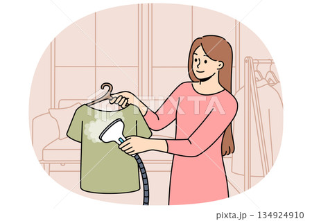 Woman housewife uses steam iron to treat clothes after washing and avoid wrinkles Woman housewife uses steam iron to treat clothes after washing and avoid wrinkles 134924910