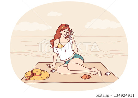 Woman sits on beach and listens to sound sea from shell, enjoying summer vacation at tropical resort Woman sits on beach and listens to sound sea from shell, enjoying summer vacation at tropical resort 134924911