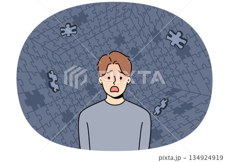 Depressed man screams during panic attack or hallucination, standing among collapsing puzzle 134924919