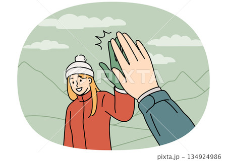 Woman tourist gives five to friend hiking in mountains to explore new picturesque places Woman tourist gives five to friend hiking in mountains to explore new picturesque places 134924986