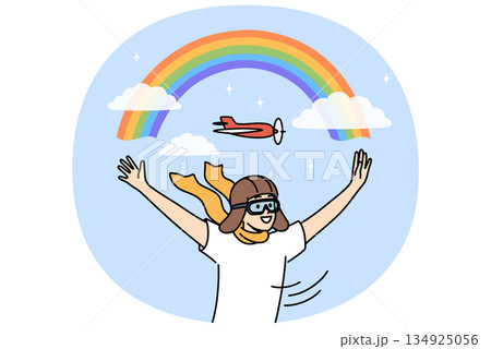 Boy in aviator hat dreams of becoming pilot and working as aviator, standing near rainbow in sky Boy in aviator hat dreams of becoming pilot and working as aviator, standing near rainbow in sky 134925056