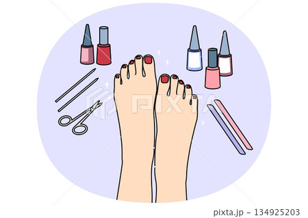 Woman feet after pedicure procedure, with nail polish and scissors near well-groomed painted nails 134925203