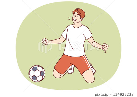 Man football player scores goal against opponent during tournament and takes winning stance on knees 134925238