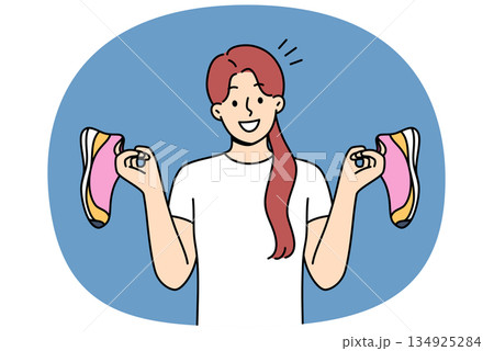 Girl holds running shoes for running or fitness, recommending use high-quality shoes for sports Girl holds running shoes for running or fitness, recommending use high-quality shoes for sports 134925284