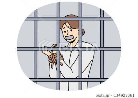 Woman hostage with hands tied standing inside prison cell and suffering due to restriction freedom 134925361