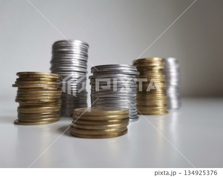 Cooper and silver coin piles on white background 134925376