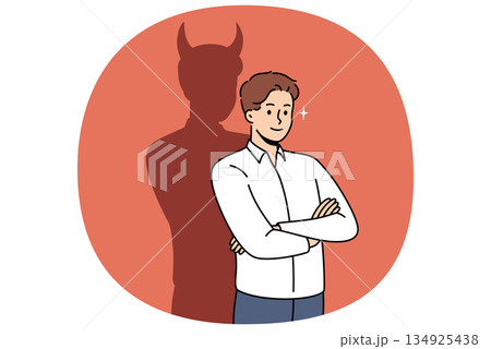 Confident businessman with bad thoughts stands with arms crossed near shadow with devil horns 134925438