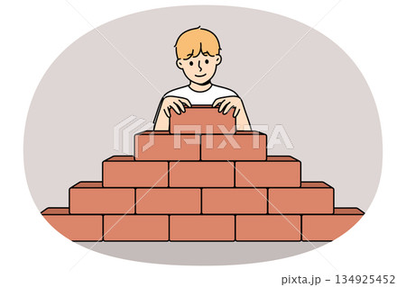 Little boy builds pyramid bricks, wanting to become builder and enroll in architectural university 134925452
