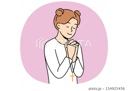 Little girl reads prayer, crossing palms near chest and holding christian cross in hands Little girl reads prayer, crossing palms near chest and holding christian cross in hands 134925456