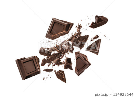 Dark chocolate pieces exploding into fragments isolated on white background with copy space Dark chocolate pieces exploding into fragments isolated on white background with copy space 134925544
