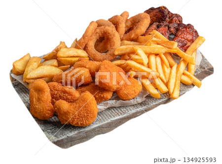 Assorted fried fast food snacks with french fries, chicken nuggets and onion rings isolated on white 134925593
