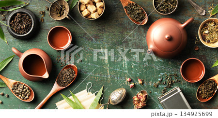 Tea Leaves and Teaware Flat Lay with Rustic Green Background Tea Leaves and Teaware Flat Lay with Rustic Green Background 134925699