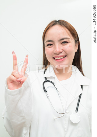 Portrait of young Asian female doctor against white background 134926669