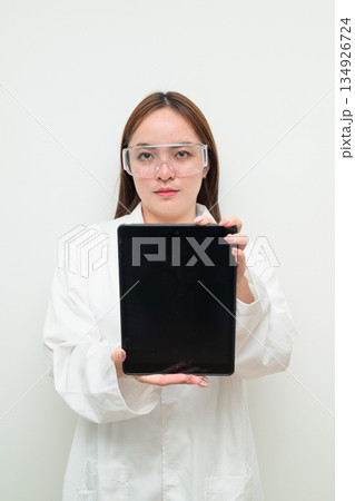 Asian female research scientist showing digital tablet screen with copy space in studio Asian female research scientist showing digital tablet screen with copy space in studio 134926724