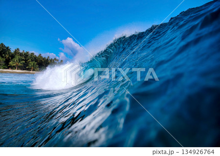 Energetic surf soaring over coral reef with dazzling sunlight reflections 134926764