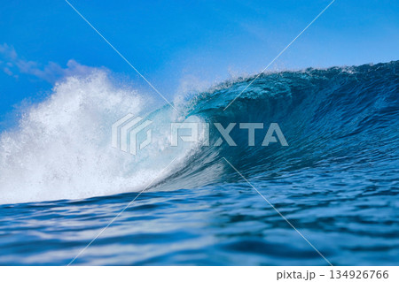 Clear Sky And Sharp Sunlight Illuminate Massive Turquoise Coastal Wave In Motion 134926766
