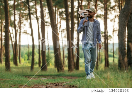 Walking forward. Handsome man is in the forest with acoustic guitar Walking forward. Handsome man is in the forest with acoustic guitar 134928198