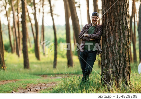 Beautiful man in cap is in the forest at daytime Beautiful man in cap is in the forest at daytime 134928209