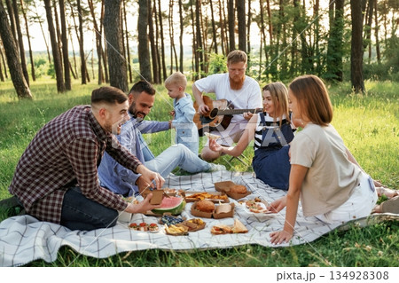 Conception of free time, wellness. Group of friends are having picnic on the field with food in eco boxes Conception of free time, wellness. Group of friends are having picnic on the field with food in eco boxes 134928308