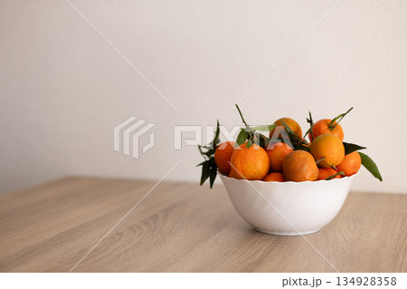 Full bowl of fresh tangerine on a wooden table. 134928358