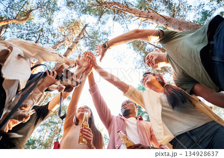 View from below of group of friends that are in the forest 134928637
