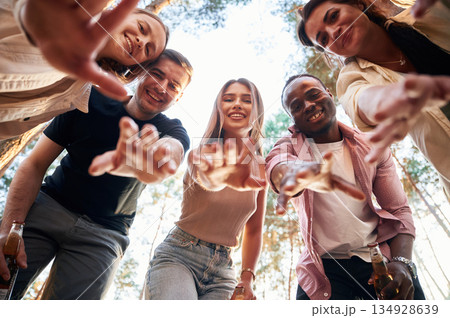 Looking down. View from below of group of friends that are in the forest Looking down. View from below of group of friends that are in the forest 134928639